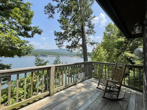 d'une terrasse avec une chaise et une vue sur le lac. dans l'établissement C18, Two bedroom, two bath log-sided loft Harbor North luxury loft cottage with hot tub cottage, à Mount Ida