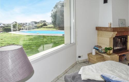 Cette chambre dispose d'une cheminée et d'une fenêtre avec vue sur la piscine. dans l'établissement Amazing Home In Pleubian, à Pleubian