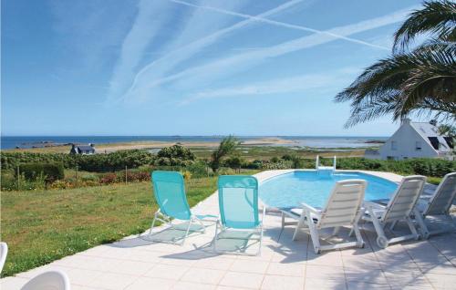 a group of chairs sitting next to a swimming pool at Amazing Home In Pleubian in Pleubian