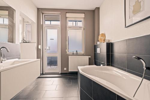 a bathroom with two sinks and a bath tub at Wohnen bei der alten Dampflok inkl. Balkon in Meckenbeuren