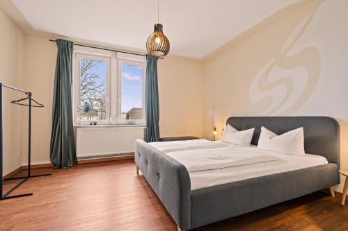 a bedroom with a bed and a large window at Wohnen bei der alten Dampflok inkl Balkon - 5 min zum Ravensburger Spieleland in Meckenbeuren