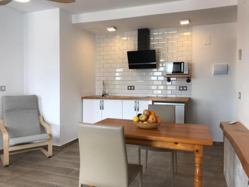 a kitchen with a table with a bowl of fruit on it at Casa Raíces del Montgo in Denia