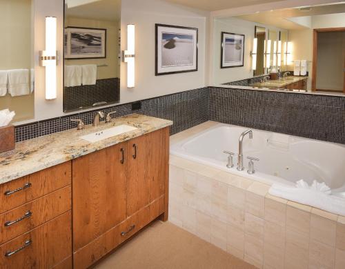 a bathroom with a tub and a sink and a mirror at The Pines 401 in Beaver Creek