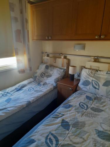 dos camas sentadas una al lado de la otra en una habitación en Millfield caravan site, caravan L6, en Ingoldmells