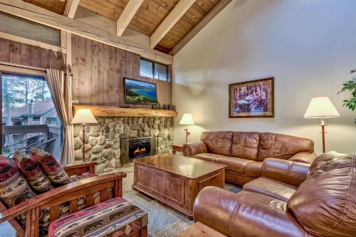 a living room with leather furniture and a stone fireplace at 511 Pine Grove in South Lake Tahoe