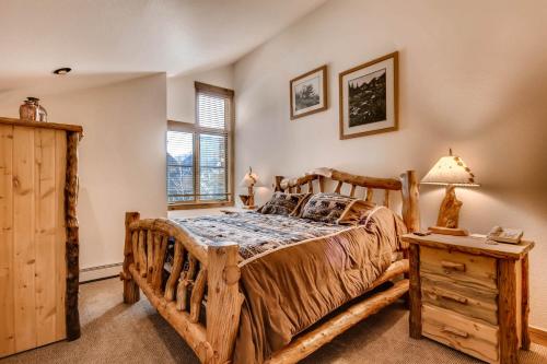 a bedroom with a wooden bed and a night stand at Ski Tip Townhomes 8713 in Keystone