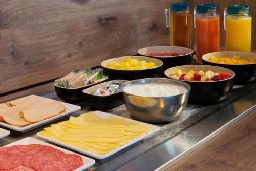 a counter with several bowls and plates of food at Brit Hotel Confort Amiens in Longueau