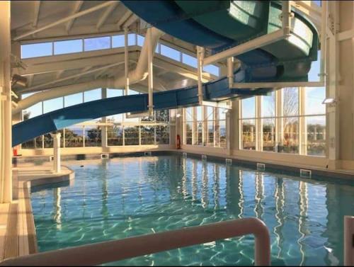a swimming pool with a slide in a building at Rosie's Seton Retreat in Port Seton