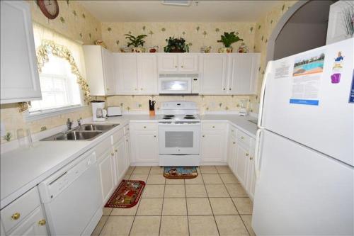 eine Küche mit weißen Schränken und einem weißen Kühlschrank in der Unterkunft 713 Ironwood Condo in Myrtle Beach