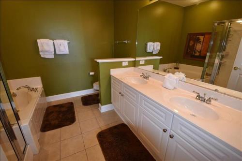 een badkamer met 2 wastafels, een bad en een douche bij 1134 The Havens in Myrtle Beach