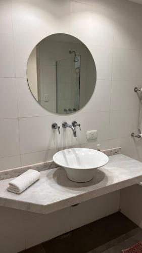 W białej łazience znajduje się umywalka i lustro. w obiekcie Administración MAIPU 1C FI Depto Premium w mieście Tandil