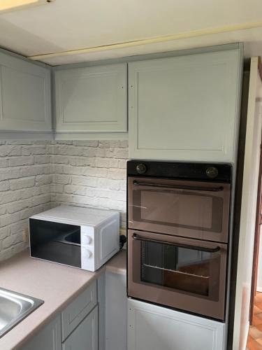 eine Küche mit Toaster und Mikrowelle in der Unterkunft L&g FAMILY HOLIDAYS 6 BERTH CORAL BEACH LAURA FAMILYS ONLY AND LEAD PERSON MUST BE OVER 30 in Ingoldmells