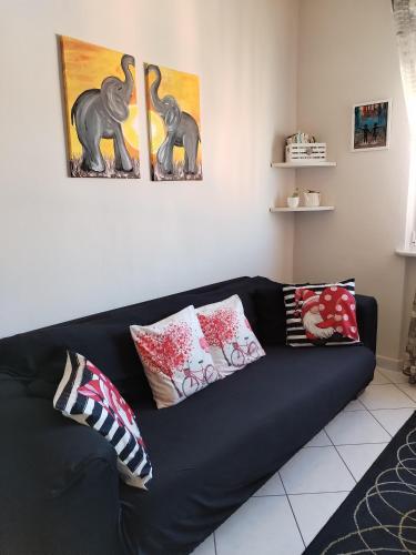 a black couch in a living room with pillows at Nido delle meraviglie in Canelli