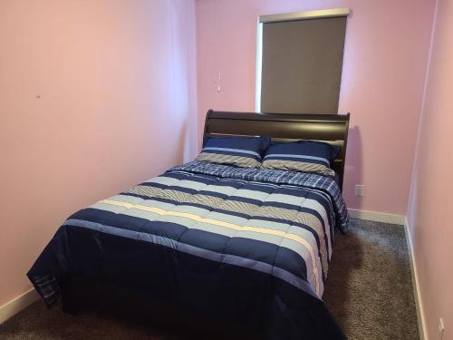 um quarto com uma cama com paredes azuis e cor-de-rosa em Winnipeg Peace Home em Winnipeg