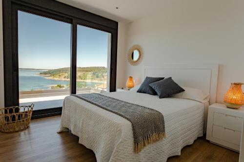 een slaapkamer met een groot bed en een groot raam bij Chalet Mirador da Pinela in Cangas de Morrazo