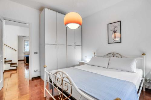 - une chambre avec un grand lit blanc et une lumière orange dans l'établissement Ciclamini 29 Casa Vacanze, à Numana