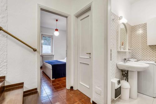 a bathroom with a white door and a sink and a bed at Ciclamini 29 - Casa Casoni in Numana