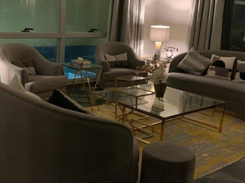 a living room with two couches and a glass table at Grey Villa in Buraydah