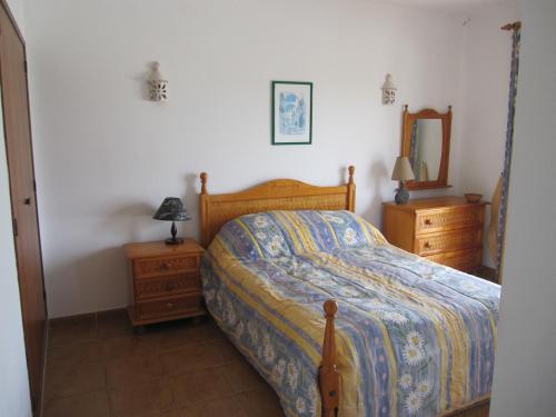 een slaapkamer met een bed, 2 dressoires en een spiegel bij Villa Figueira in Figueira