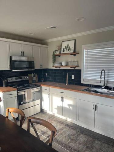 a kitchen with white cabinets and a table with chairs at Piper's Place - 2 Bedroom House in DT Hamilton in Hamilton