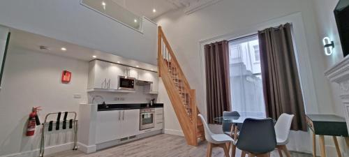 eine Küche und ein Esszimmer mit einem Tisch und Stühlen in der Unterkunft Hyde Park Superior Apartments in London