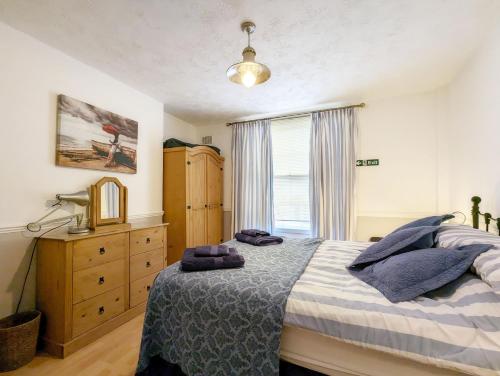 a bedroom with a bed and a dresser and a window at Dolphin House, Emsworth in Emsworth