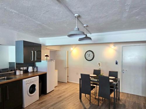 a kitchen and dining room with a table and chairs at Albert Apartment with free Gym in Penzance