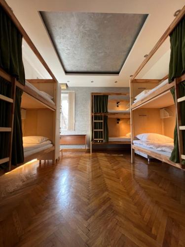 a room with two bunk beds and a wooden floor at Cabbage Hostel in Belgrade