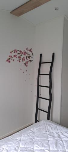 a bedroom with a bed and a painting of a tree at Chalets op Minicamping Dorpszicht in Gapinge