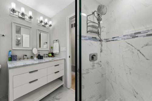 a bathroom with a walk in shower next to a sink at A Wave From It All in Largo