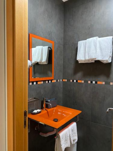 a bathroom with a orange sink and a mirror at A Berlenga 2 in Nazaré