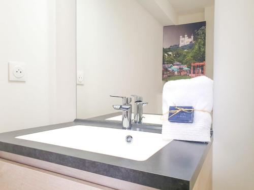 uma casa de banho com um lavatório e um espelho em Le Loft d'Or à 10min de Lyon em Champagne-au-Mont-dʼOr