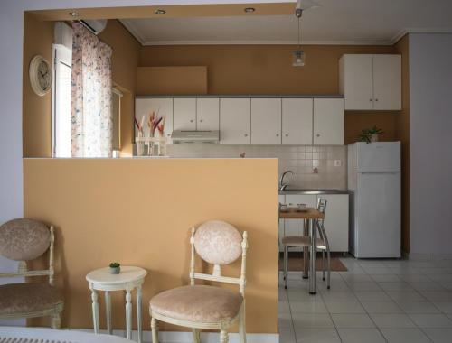 a kitchen with white cabinets and chairs and a counter at 4keys House 3 in Tripoli