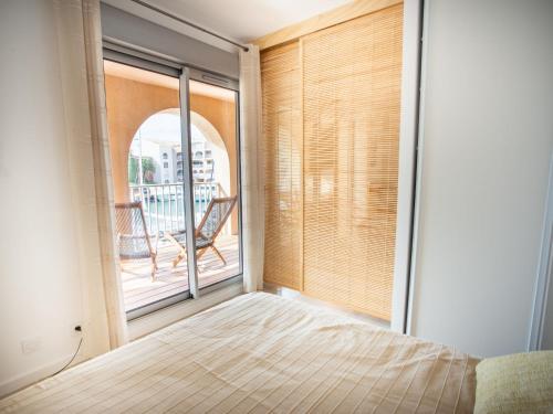 - une chambre avec une grande fenêtre, un lit et un balcon dans l'établissement Apartment Port de la Gavine I-1 by Interhome, à Hyères