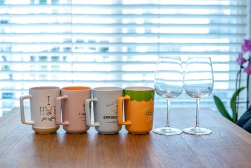 a group of coffee mugs and wine glasses on a table at Cozy 2 beds Spacious rooms,Close to transit in Vancouver