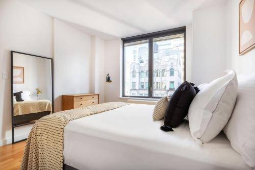 Ένα ή περισσότερα κρεβάτια σε δωμάτιο στο Sutton Place 2BR w Gym nr Rockefeller Plaza NYC-519