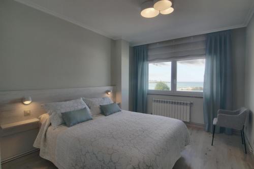 a bedroom with a large bed and a window at Apartamento Playa de Altar in Barreiros