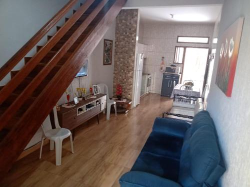 a living room with a blue couch and a staircase at Meu Aconchego in Cabo Frio