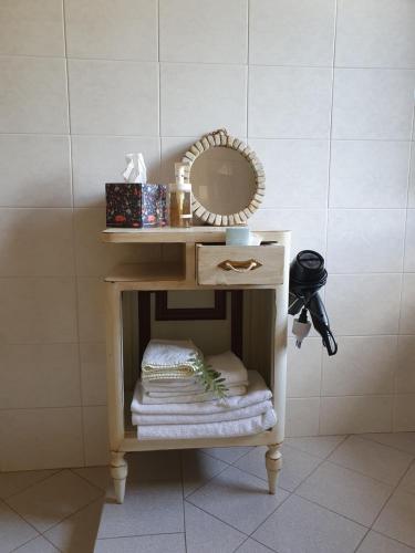 einen kleinen Tisch mit einem Spiegel und Handtüchern in der Unterkunft Pietra d'Acqua B&B in the woods in Buti