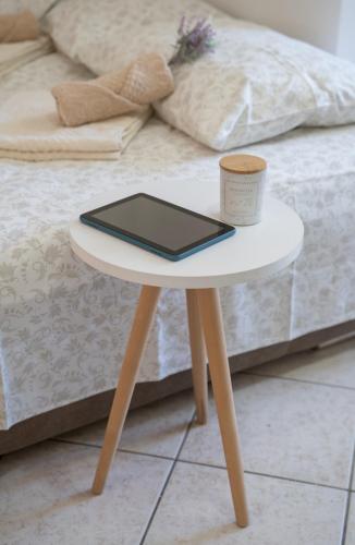 a table with a tablet and a cup on a bed at Apartmani Zukic in Risan