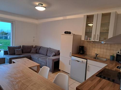 Il dispose d'une cuisine et d'un salon avec un canapé et une table. dans l'établissement Cottage Le Cabanon, à Huisnes-sur-Mer