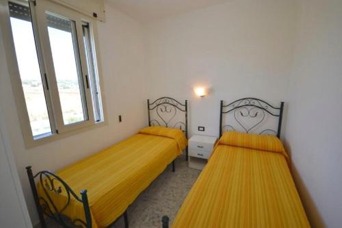 Dos camas en una habitación con camas amarillas. en 059 e 060 Spiaggia di SalentoinVacanza.Com, en Torre Pali