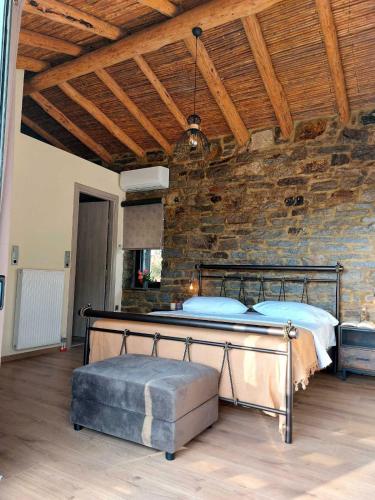 a bedroom with a bed and a stone wall at by karakas Λίθινο in Kálamos