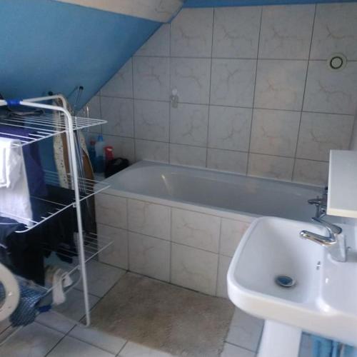 une salle de bain avec une baignoire et un lavabo dans l'établissement Entre vigne et rivière, à Écuelles