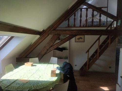 a attic room with a bed and a staircase at Entre vigne et rivière in Écuelles