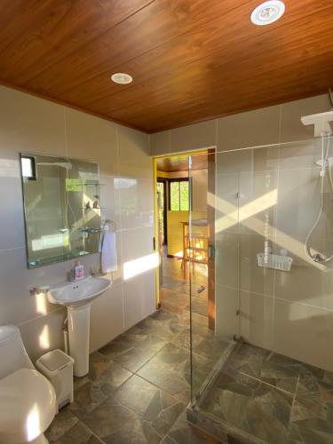 a bathroom with a glass shower and a sink at Indigo Container House in San Luis