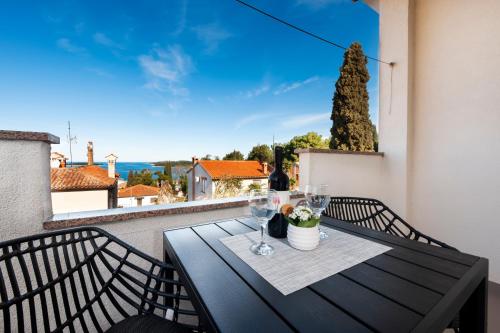 uma mesa preta com copos de vinho na varanda em Apartments & Room Anita em Rovinj