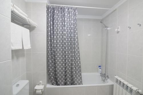 a bathroom with a shower curtain and a bath tub at Apartamento Playa de Altar in Barreiros