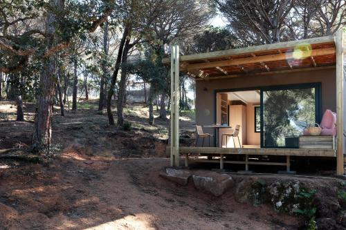 una pequeña casa en el bosque con una mesa y sillas en wecamp Santa Cristina, en Santa Cristina d'Aro