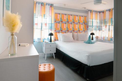 a bedroom with a large bed with colorful windows at Fashion Boutique Hotel in Miami Beach